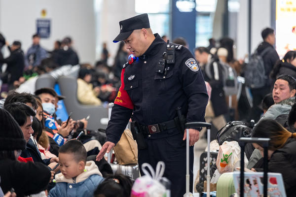 在重庆西站候车厅，牟浩提醒候车旅客照看好随行儿童和行李物品。王新刚摄